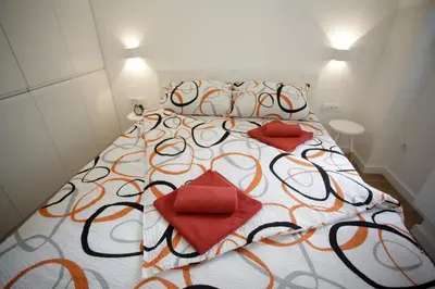a large bed with two red pillows on it at City Center Belgrade Cozy Apartment Skadarlija in Belgrade