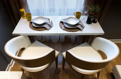 a white table with two chairs and a table with glasses at Supreme Palace Cube in Belgrade