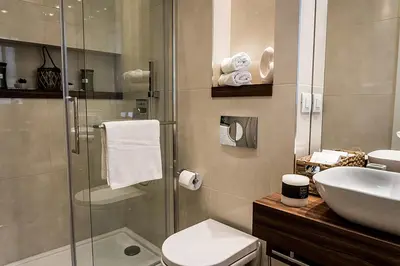 a bathroom with a shower and a toilet and a sink at Supreme Palace Cube in Belgrade
