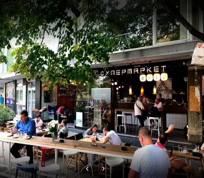 a group of people sitting at tables in a restaurant at Supreme Palace Cube in Belgrade