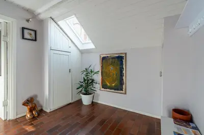 an attic hallway with a painting and a potted plant at KLARA VRACAR 90 m2, dve i po spavace sobe in Belgrade