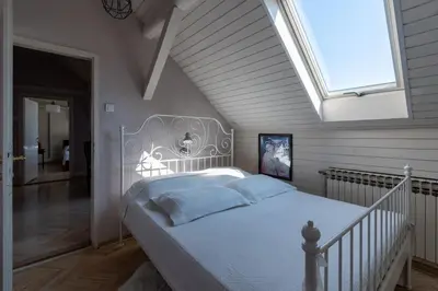 a bedroom with a large white bed with a skylight at KLARA VRACAR 90 m2, dve i po spavace sobe in Belgrade