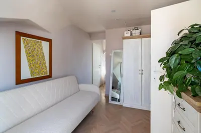a living room with a white couch and a plant at KLARA VRACAR 90 m2, dve i po spavace sobe in Belgrade
