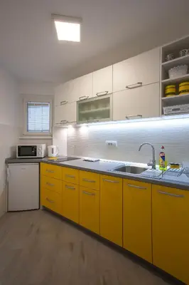 a kitchen with yellow cabinets and a sink at Tamy lux apartment in Belgrade