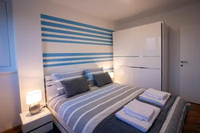 a bedroom with a bed with blue and white stripes at Tamy lux apartment in Belgrade