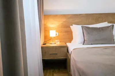 a bedroom with a bed and a lamp on a night stand at Thomas Residence in Belgrade
