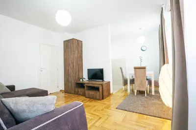 a living room with a couch and a television and a table at Thomas Residence in Belgrade