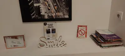 a white wall with a picture and some books at White Pearl in Belgrade