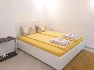a small bedroom with a bed with towels on it at White Pearl in Belgrade