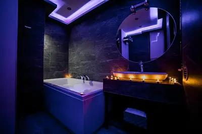 a bathroom with a tub and a sink with lights at Sinergija in Belgrade