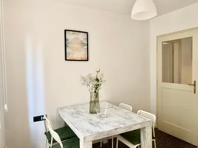 a white table with a vase of flowers on it at Star apartment 2 in Belgrade