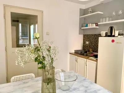 a kitchen with a table with a vase of flowers on it at Star apartment 2 in Belgrade