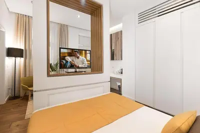 a bedroom with a mirror and a tv on a wall at Dominic Smart & Luxury Suites - Terazije in Belgrade