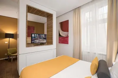 a bedroom with a bed and a mirror and a tv at Dominic Smart & Luxury Suites - Terazije in Belgrade