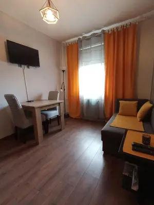 a living room with a bed and a desk and a table at Two Rivers Apartment in Belgrade