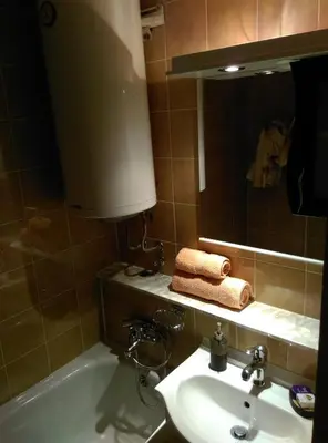 a bathroom with a sink and a tub and a mirror at Two Rivers Apartment in Belgrade