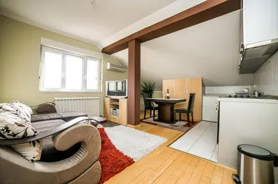 a living room with a couch and a kitchen at Residence Amelie in Belgrade