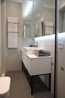 a white bathroom with a sink and a mirror at Temple Apartments Belgrade in Belgrade