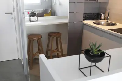 a kitchen with a sink and a counter with stools at Temple Apartments Belgrade in Belgrade