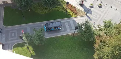 an overhead view of a blue truck parked in a park at OBILIĆ in Belgrade