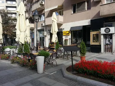 an outdoor cafe with tables and chairs with umbrellas at OBILIĆ in Belgrade