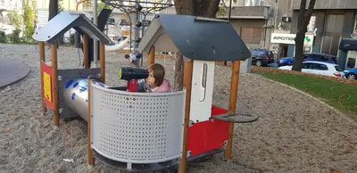 a little girl sitting in a train on a playground at OBILIĆ in Belgrade