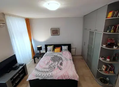 a small bedroom with a bed with a pink blanket at City Center Lovely Studio Apartment in Belgrade