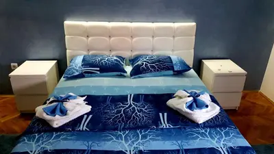 a bed with blue and white sheets and blue pillows at Apartment Centar Exclusive Smederevo in Smederevo
