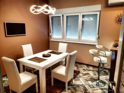 a dining room with a white table and chairs at Apartment Centar Exclusive Smederevo in Smederevo