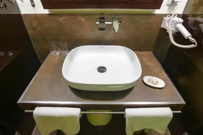 a sink in a bathroom with a phone and towels at 4Rooms 4U in Belgrade