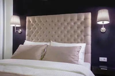 a bedroom with a large white bed with two lamps at 4Rooms 4U in Belgrade