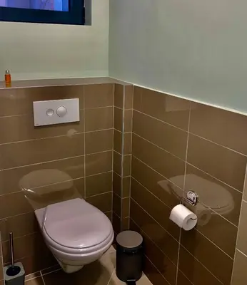 a bathroom with a toilet and a toilet paper dispenser at 4Rooms 4U in Belgrade