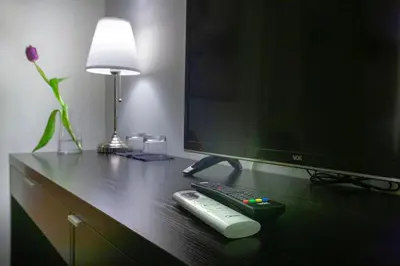 a desk with a television and a remote control at 4Rooms 4U in Belgrade