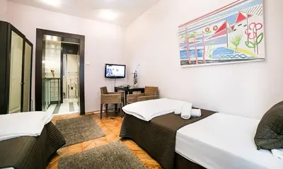 a room with two beds and a table in it at Piano Cube in Belgrade