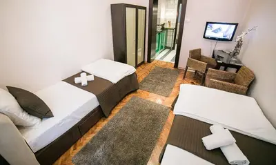 a bedroom with two beds and a living room with a tv at Piano Cube in Belgrade