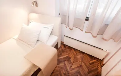 a small room with a white couch and a window at Piano Cube in Belgrade