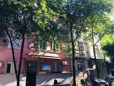 a man standing in front of a pink building at Piano Cube in Belgrade