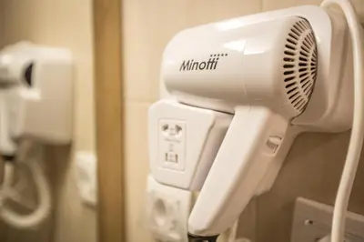 a hair dryer is attached to a wall in a bathroom at Hotel Mar Garni in Belgrade