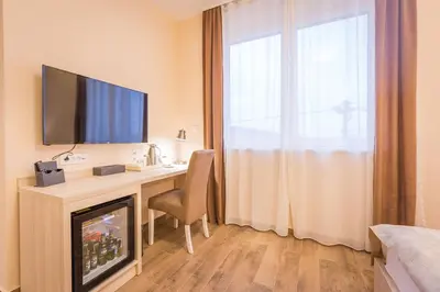 a hotel room with a desk with a television on it at Hotel Mar Garni in Belgrade