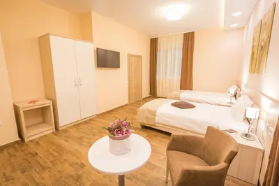 a hotel room with a bed and a table at Hotel Mar Garni in Belgrade