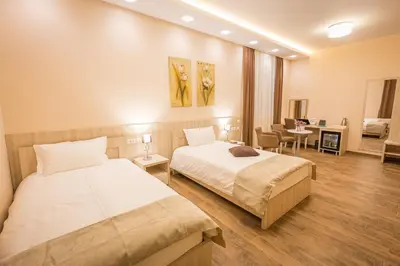 a bedroom with two beds and a living room at Hotel Mar Garni in Belgrade