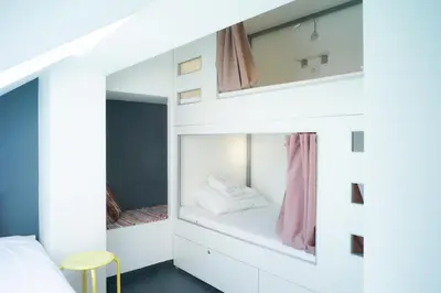 a bedroom with a bed and a mirror at Good People Design Hostel in Belgrade