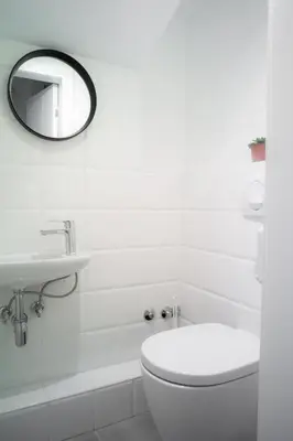 a white bathroom with a toilet and a sink at Good People Design Hostel in Belgrade