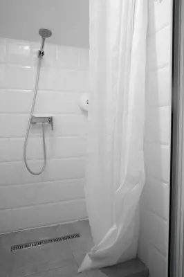 a shower with a shower curtain in a bathroom at Good People Design Hostel in Belgrade