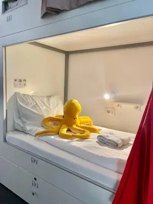 a yellow rubber duck sitting on top of a bed at Good People Design Hostel in Belgrade