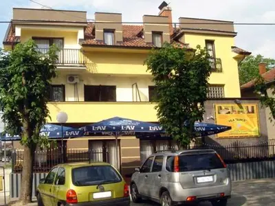 two cars parked in front of a building at Hotel Vila Sunce in Stara Pazova