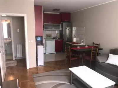 a living room and kitchen with a table and a couch at Apartman AS in Belgrade