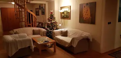 a living room with a christmas tree and two chairs at NOBLES APARTMENT 4**** in Belgrade