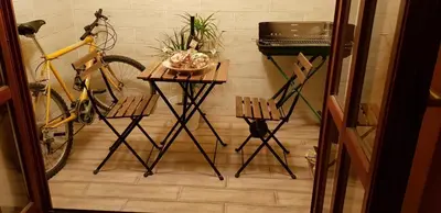 a table and two chairs in a room with a bike at NOBLES APARTMENT 4**** in Belgrade