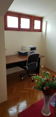 an office with a desk with a chair and a vase of flowers at NOBLES APARTMENT 4**** in Belgrade